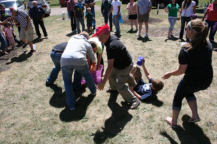 In this game, competitors soak up water with sponges and race to fill ice cream buckets.