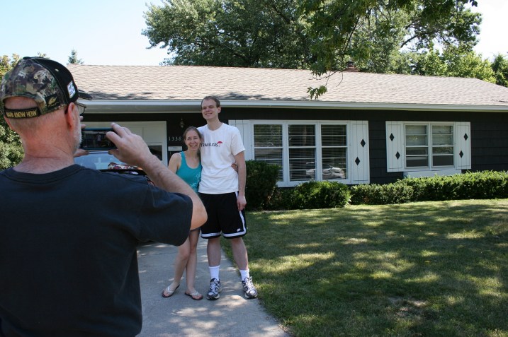 My husband photographs our eldest daughter and her fiance in front of the rental house that will soon be their new home.