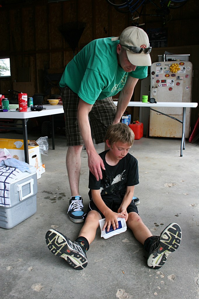 My nephew Nate tends to his nephew, Tristan, following a hand injury during a gunny sack race.