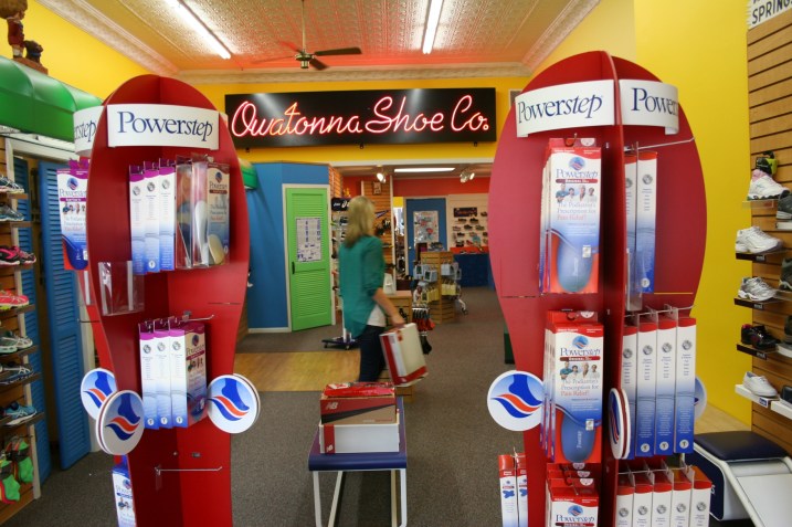 A clerk retrieves a box of shoes for a customer.