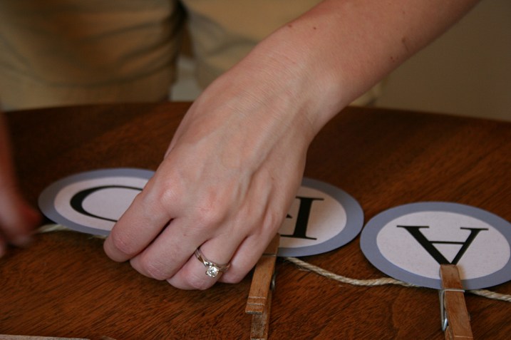 Card gift boxes, in my opinion, are not exactly original. So the bride and I came up with an idea that was simple and vintage and personal. Here Amber attaches CARDS letters to jute with clothespins from my clothespin bag.