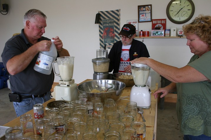 Brian, left, and Lanae blend the horseradish with vinegar in blenders while Randy uses the food processor.