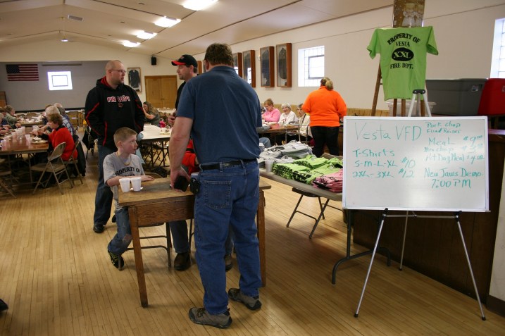 That's Vesta firefighter Neal Hansen to the left behind the table, photographed at the Vesta Fire Department  Pork Chop Feed in March.