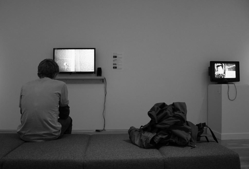 A student studies a portion of "The Intersection Between Book, Film, and Visual Narrative" in the Kaemmer Family Gallery.