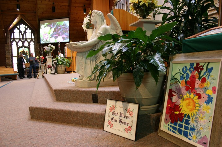 Flower art buffeted both sides of the chancel, here near the baptismal font and pulpit.