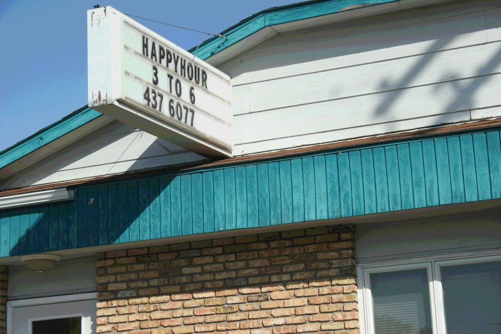In Vermillion, near Hastings, a bar advertises the ever popular happy hour. Minnesota Prairie Roots file photo 2012.