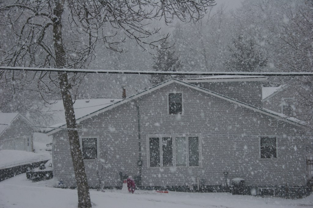 As soon as the snow began, my neighbor girl was outside building a snowman and a snow fort.