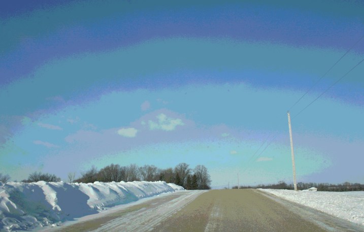 A ridge of plowed snow edges a country road near Montgomery, Minnesota.