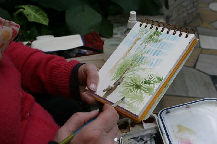 Watercolor artist Kathleen Richert paints a fountain in the Palm Dome.