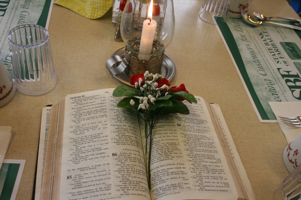 Bibles, florals and candles decorated tables.