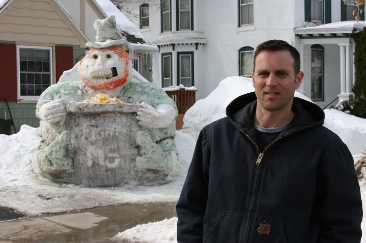Faribault resident Kurt Klett and his latest snow sculpture, a leprechaun with a pot of gold.
