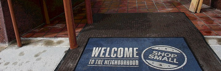 Remember to shop local as noted in this mat at the entrance to The Nook & Cranny. Edited photo.