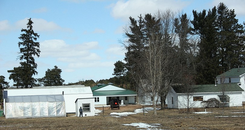 My single Wisconsin Amish photo during our most recent trip shows and Amish buggy in a farmyard and an Amish teen standing next to a small outbuilding.