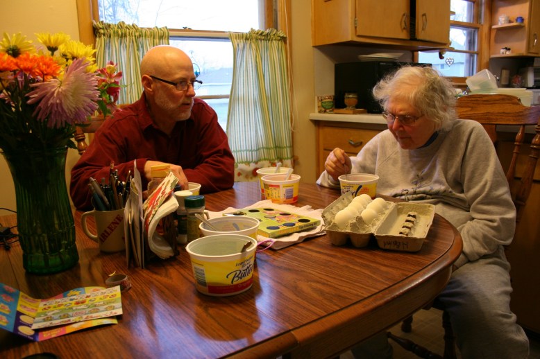 My husband and mom dye eggs at her kitchen table Saturday evening.