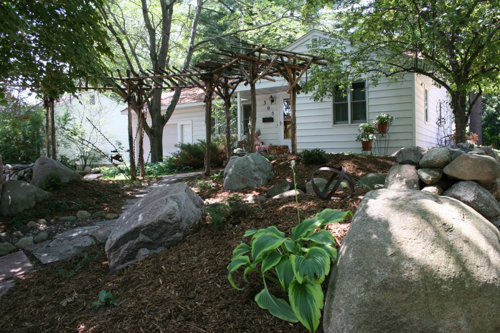 A rustic arbor and rocks define the front yard created by Switzer Landscaping.