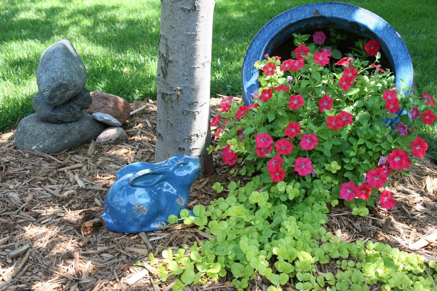 Impatiens spill from a tipped pot.