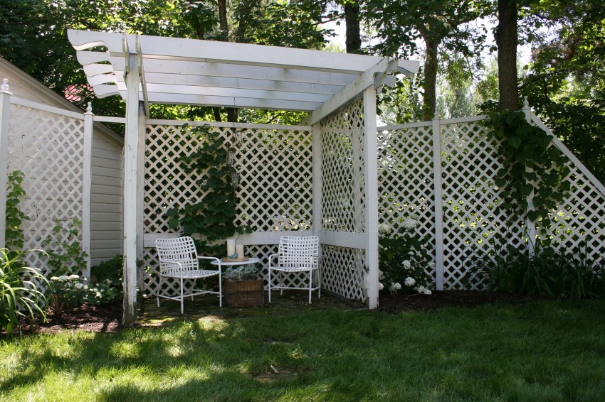 Latticework accents a corner garden pergola.