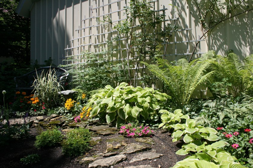 An inviting spot, complete with trellis, to sit a spell next to the garage.