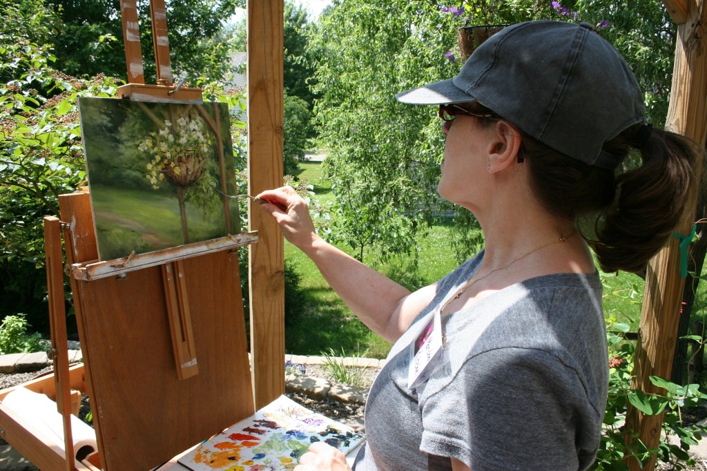 Artist Marsha Kitchel paints on the patio.