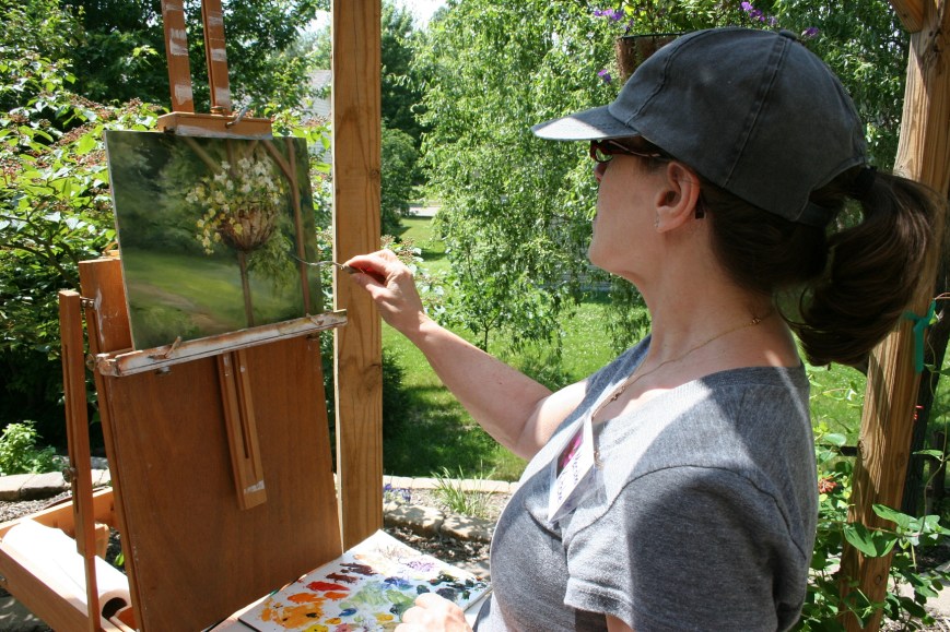 Artist Marsha Kitchel paints on the patio.