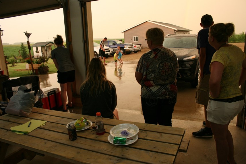 Gathering inside the garage to watch the kids playing in the rain.