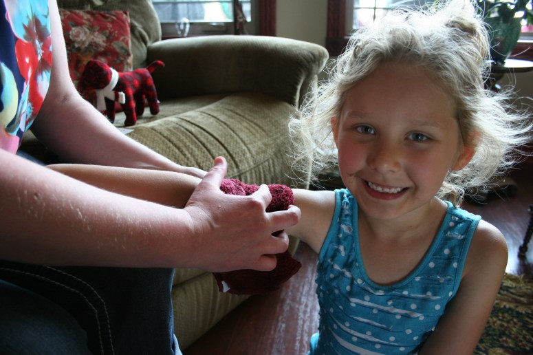 STEP ONE: Applying Ari's tattoo with a wet washcloth.