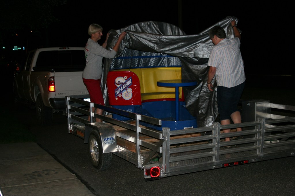 Tami Schluter, left, and Peggy Keilen reveal the restored car to an appreciative audience Wednesday evening.
