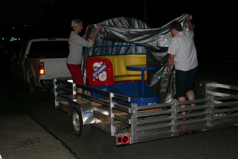 Tami Schluter, left, and Peggy Keilen reveal the restored car to an appreciative audience Wednesday evening.