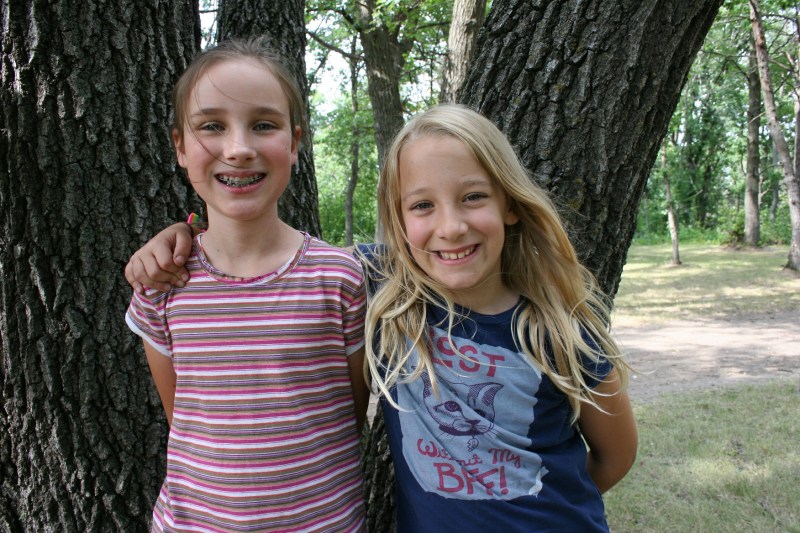 Cousins Beth, left, and Keira paused for a photo as they scampered through the woods looking for a tree to climb. They never found one they could both ascend.