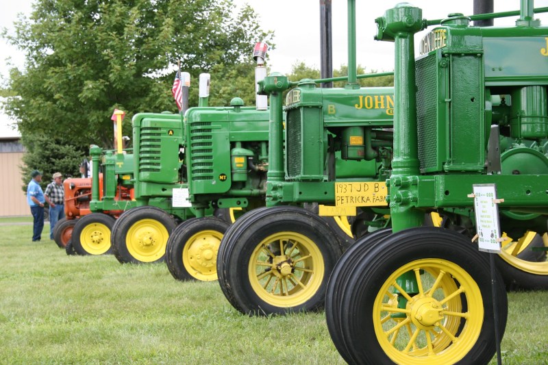 Rows and rows of tractors, including these John Deeres, line the grounds.