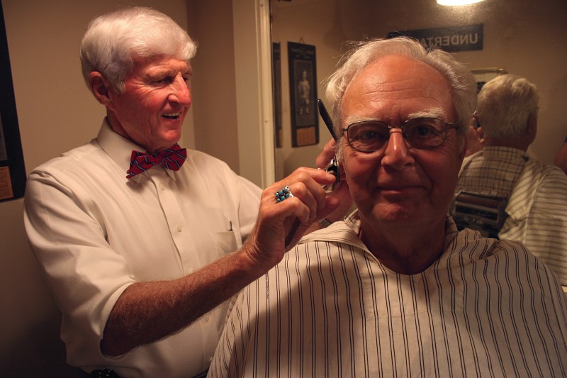 Barber Tom with customer LeRoy inside the museum barbershop.