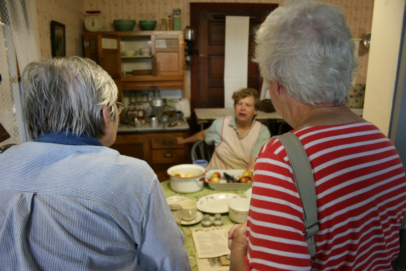 A Night at the Museum attendees visit with Mrs. Morris, who was peeling apples in her kitchen.