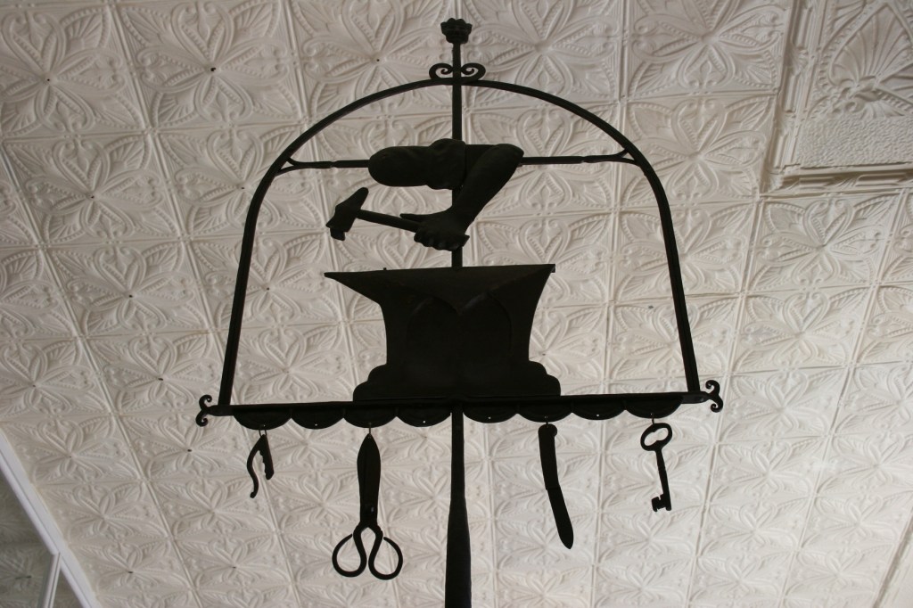 Symbols of the trade for blacksmithing and tin cutting.