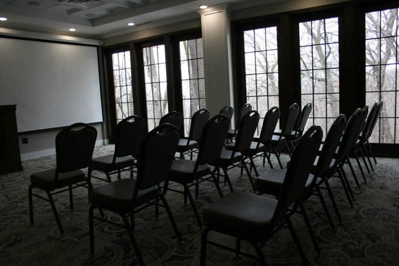 In a sectioned off meeting space, windows showcase the woods.