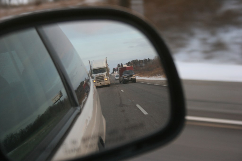 A side mirror on our van reflects traffic along Interstate 35.