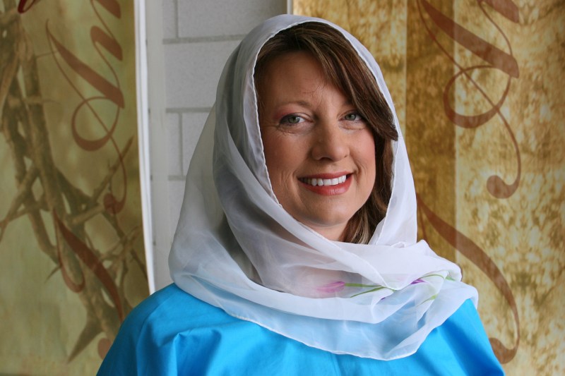 Volunteer Theresa speaks to participants about Jesus' ride into Jerusalem on Palm Sunday.