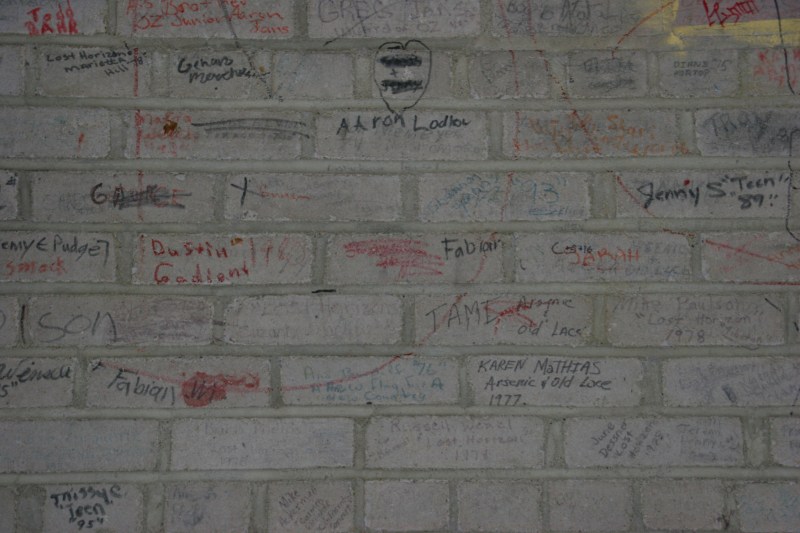 Students involved in theatrical productions signed the stage wall behind the stage curtain.