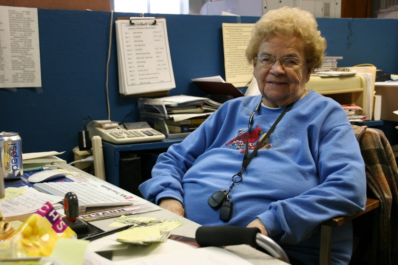 Janis Ray sits at the desk in a former classroom turned office space.