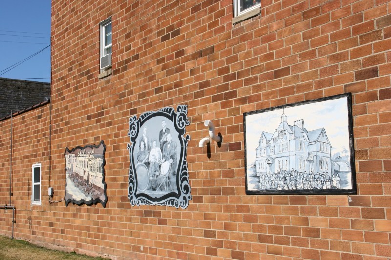 Murals grace the sides of two brick buildings sandwiching a vacant lot that is now a downtown mini park.