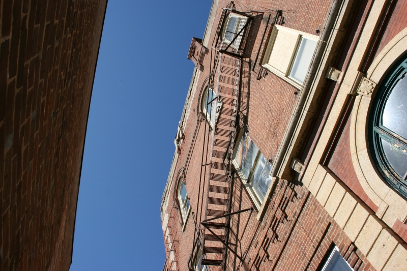 A stairway appears like a work of art on the side of an aged building.