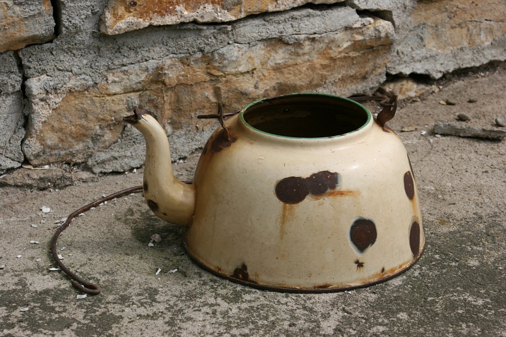 This is one of two old tea kettles sitting near the water pump. I assume they are there for watering flowers and plants.
