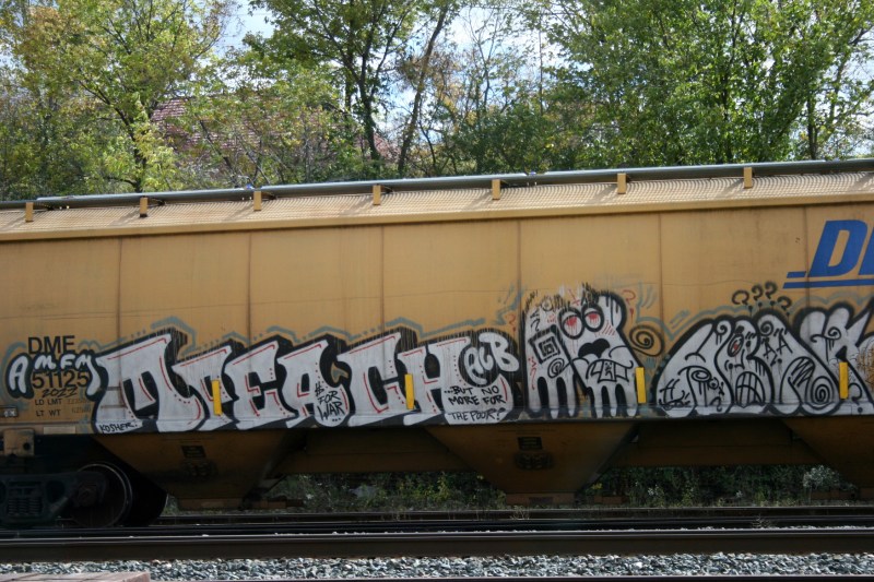 Trains run along the river by the grain elevators.