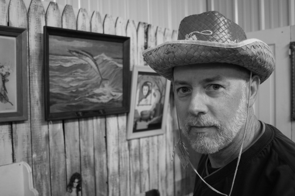 Modeling a vintage straw cowboy hat, like those we wore as children, in a North Mankato antique shop several years ago.