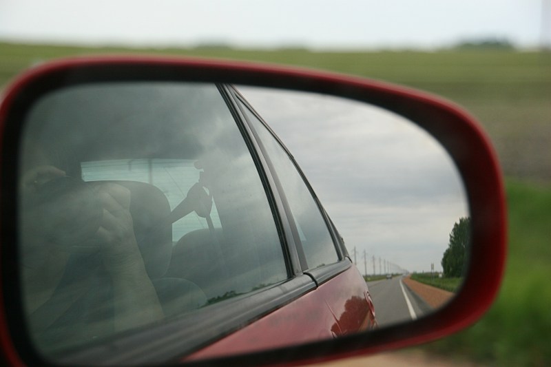 Minnesota State Highway 68 south of Morgan stretches out behind me in this snapshot taken of the passenger side mirror. Green breaks this monotonous stretch of roadway.
