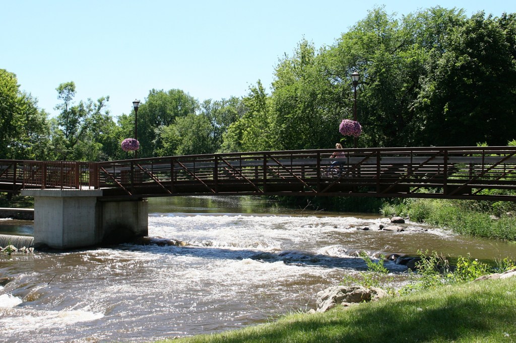 A recreational trail slices through Morehouse Park, bridging the Straight River.