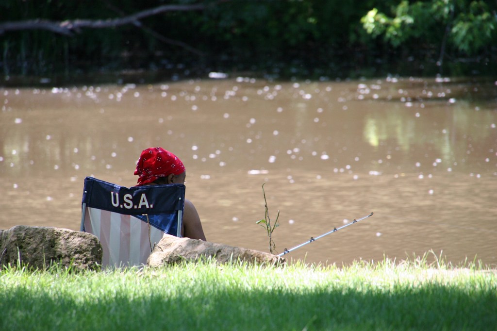 On a beautiful summer afternoon, a woman fishes the Straight River.