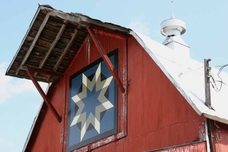 The barn quilt adds an artistic touch to this vintage barn.