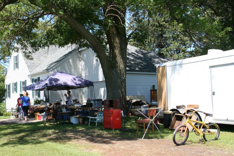 A vendor set up under the shade trees by the house.