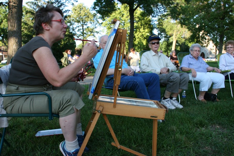 Irina Mikhaylova works on a portrait of the couple in the background.