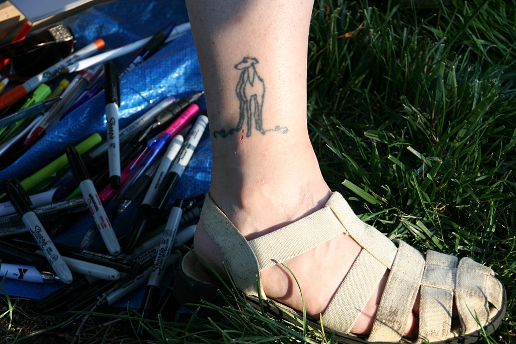 Tami's tools lie at her feet. Years ago, Tami designed the greyhound tatoo inked onto her leg in Vegas.